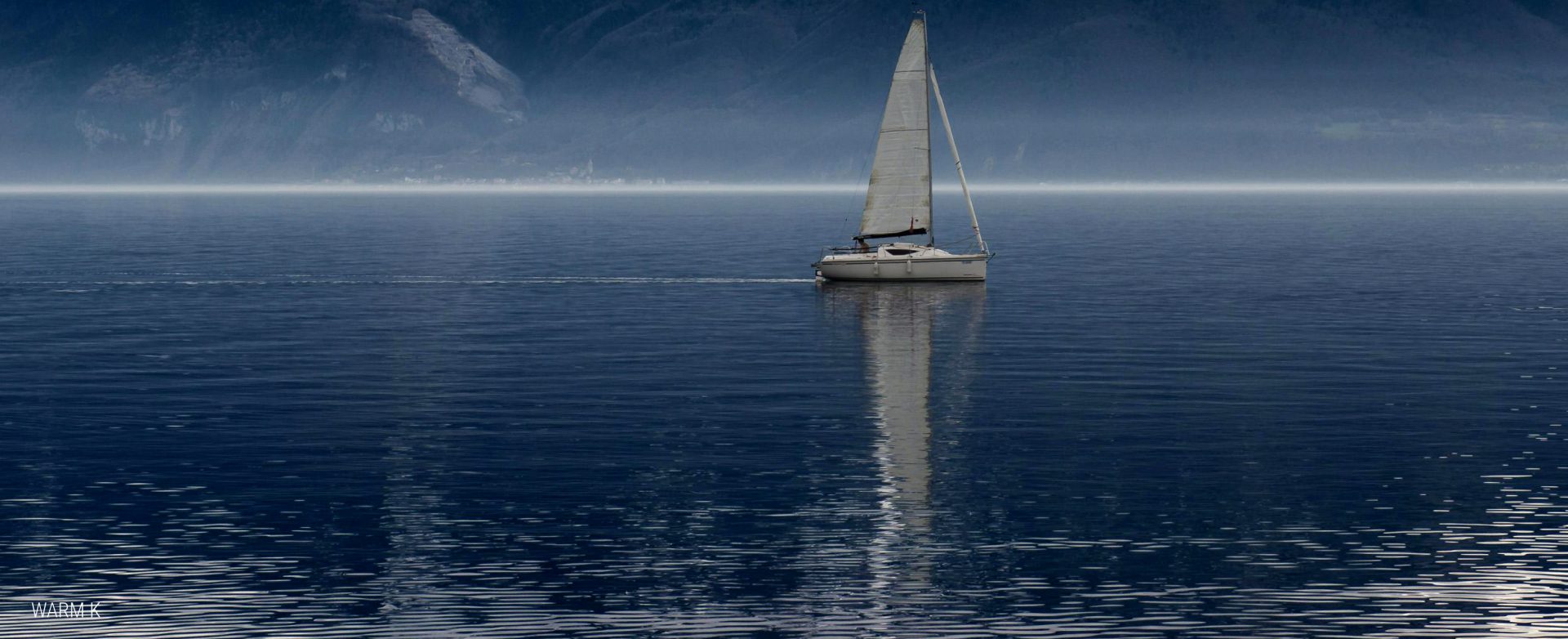 A yacht gently sailing close to the horizon