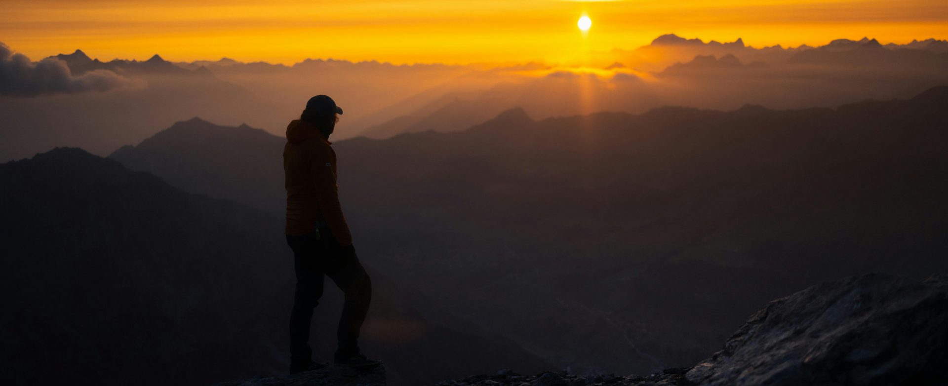 Man in mountains staring at the sunset